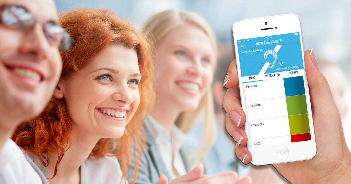 A smiling group; one person holds an iPhone running the 'Audio Everywhere' app showing a multi-language channel list.
